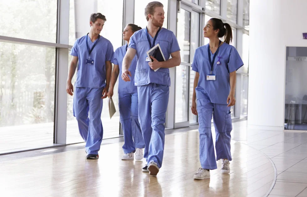 a group of people wearing blue scrubs walking
