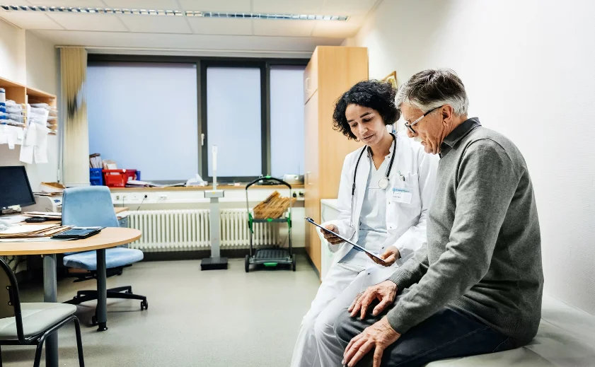 a doctor is talking to a patient in a doctor's office.