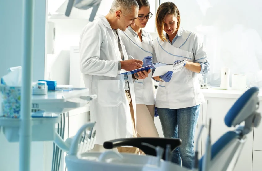 a group of people in lab coats looking at a file
